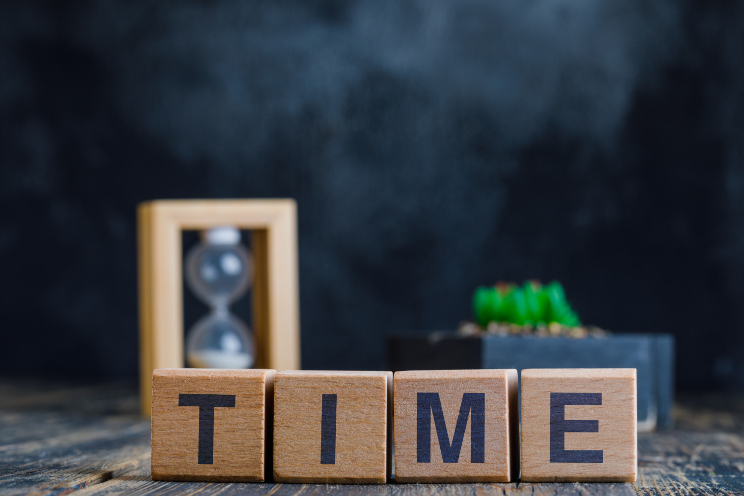 business-concept-with-time-word-wooden-cubes-hourglass-plant